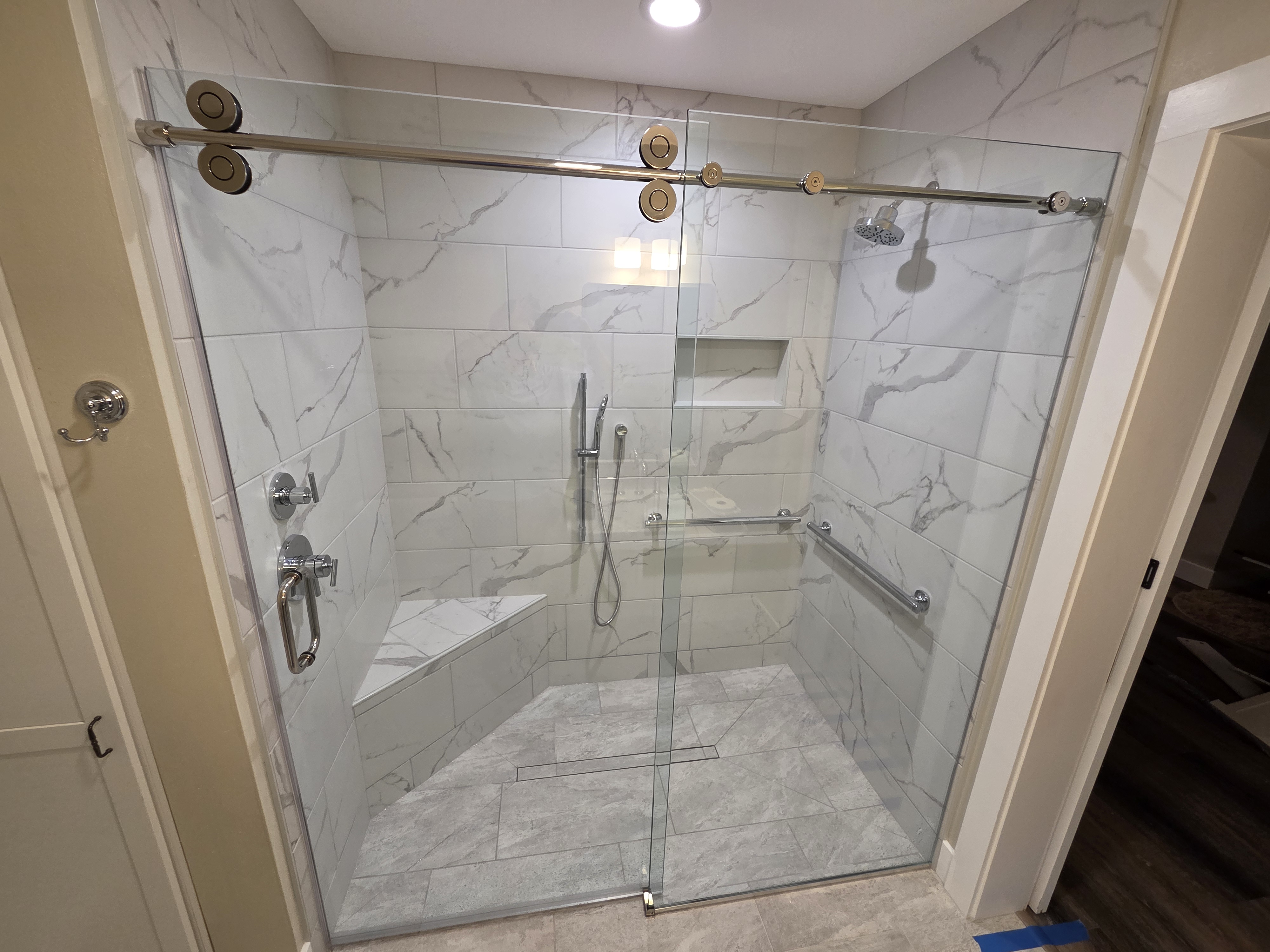 Large format tile shower with frameless glass
